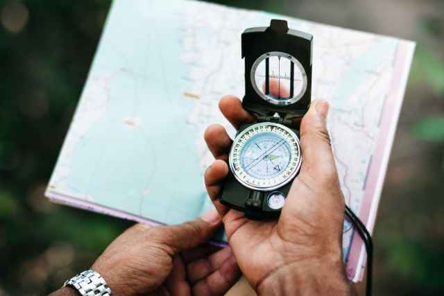 person holding black compass
